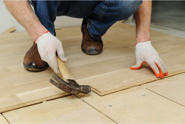 Worker Laying hardwood parquet